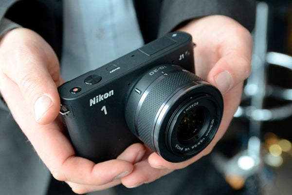 Nikon 1 5Hands holding a Nikon 1 J1 mirrorless camera.